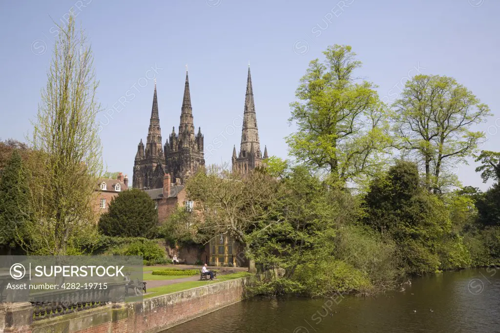 England, Staffordshire, Lichfield. The three spires of the Cathedral of St Mary and St Chad viewed across Minster Pool and Memorial Gardens in the historic city centre.