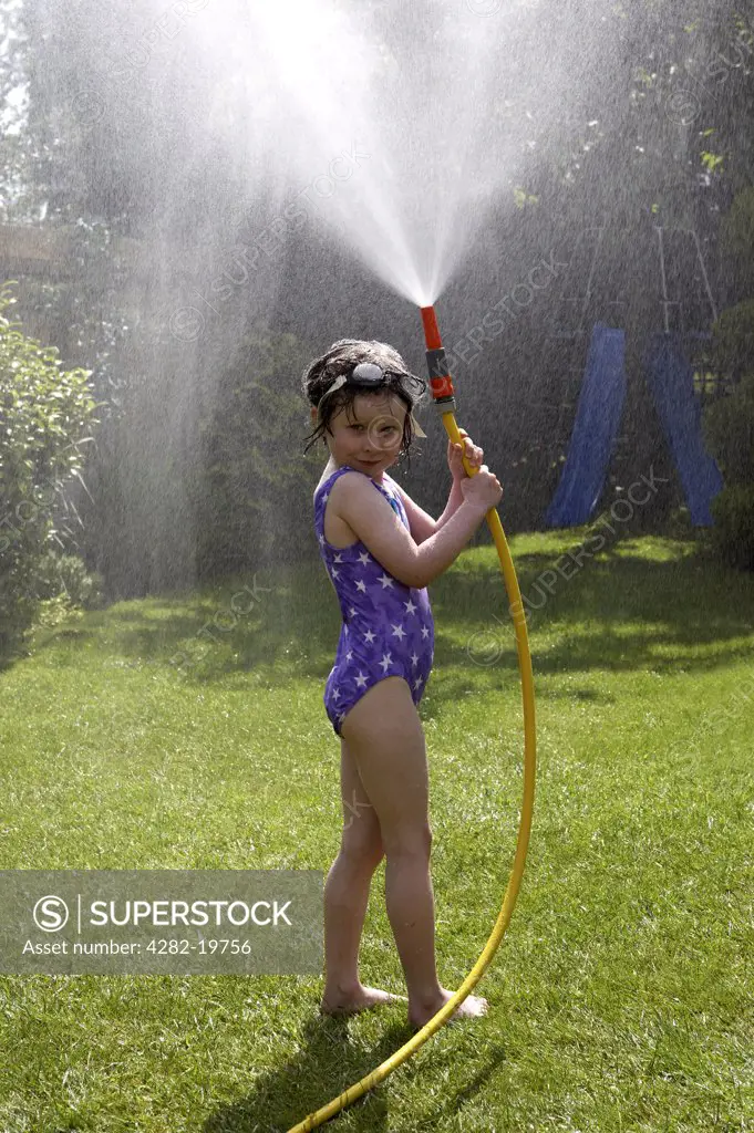 England, Tyne and Wear, Gateshead. Child having fun playing with hose pipe.