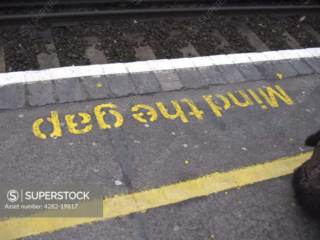 England, London, Hammersmith. Mind the Gap sign on a station platform.