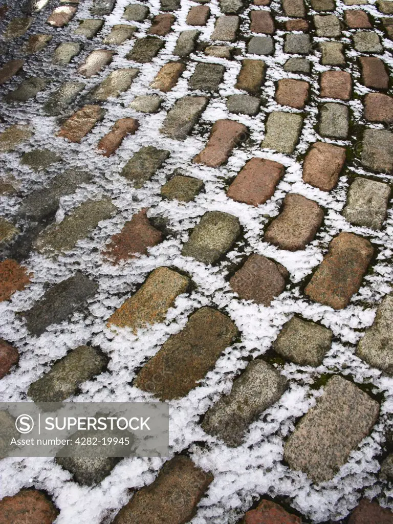 Scotland, Shetland, Lerwick. Snow covered cobbles surrounding war memorial at Hillhead on Shetland.