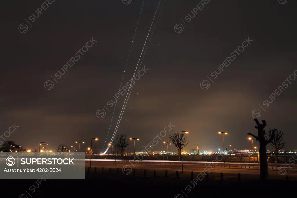England, London, Heathrow. Light trail from an aircraft taking off from London Heathrow airport at dusk.