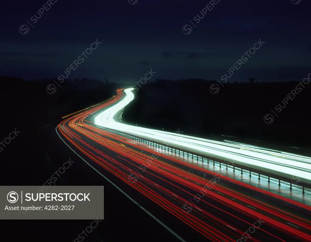 England, Essex, near Harlow. Light trails from traffic on the M11 motorway at night.