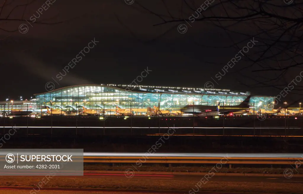 England, London, Heathrow. Aircraft at the boarding gates outside Terminal Five at Heathrow airport at night.