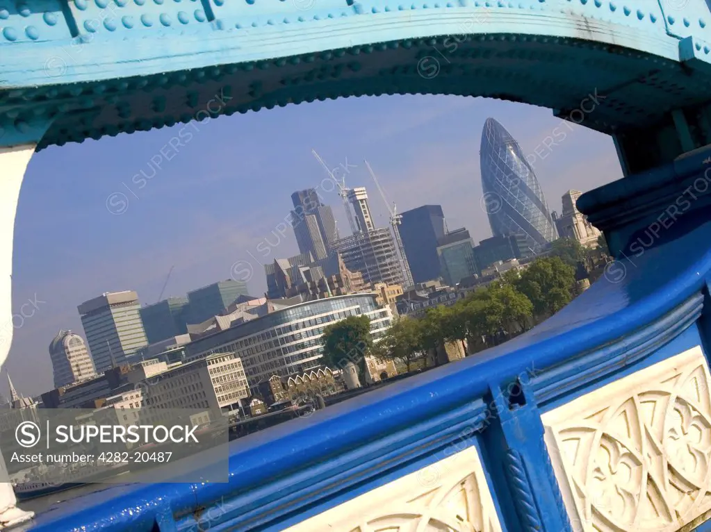 England, London, City of London. A view through the steel structure of Tower Bridge to the modern skyline and famous landmarks of the City of London.