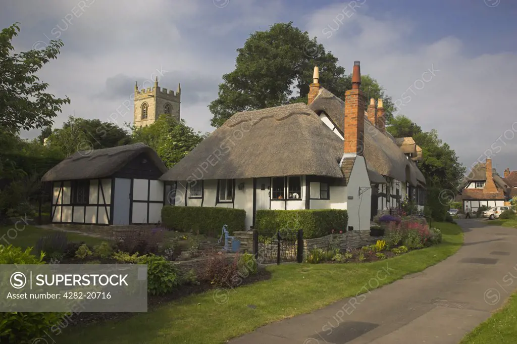 England, Warwickshire, Welford-on-Avon. Thatched Cottages and St Peter's Parish Church in the picturesque village of Welford-on-Avon, County Winner or Runner Up in the Warwickshire ""Best Kept Village Competition"" on twelve occasions since 1991.