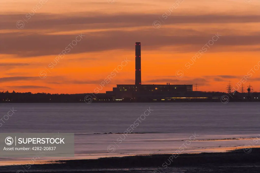 England, Hampshire, Fawley. View over Southampton Water at sunset towards Fawley Power Station from Titchfield Haven.