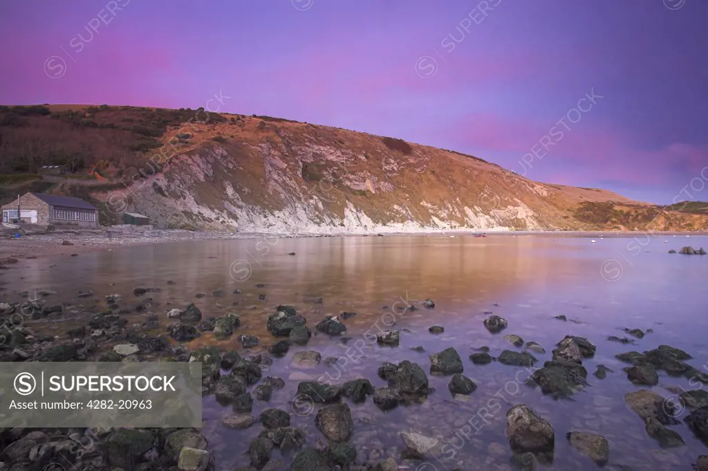 England, Dorset, Lulworth. Lulworth Cove just after sunset, the after glow producing pink clouds.