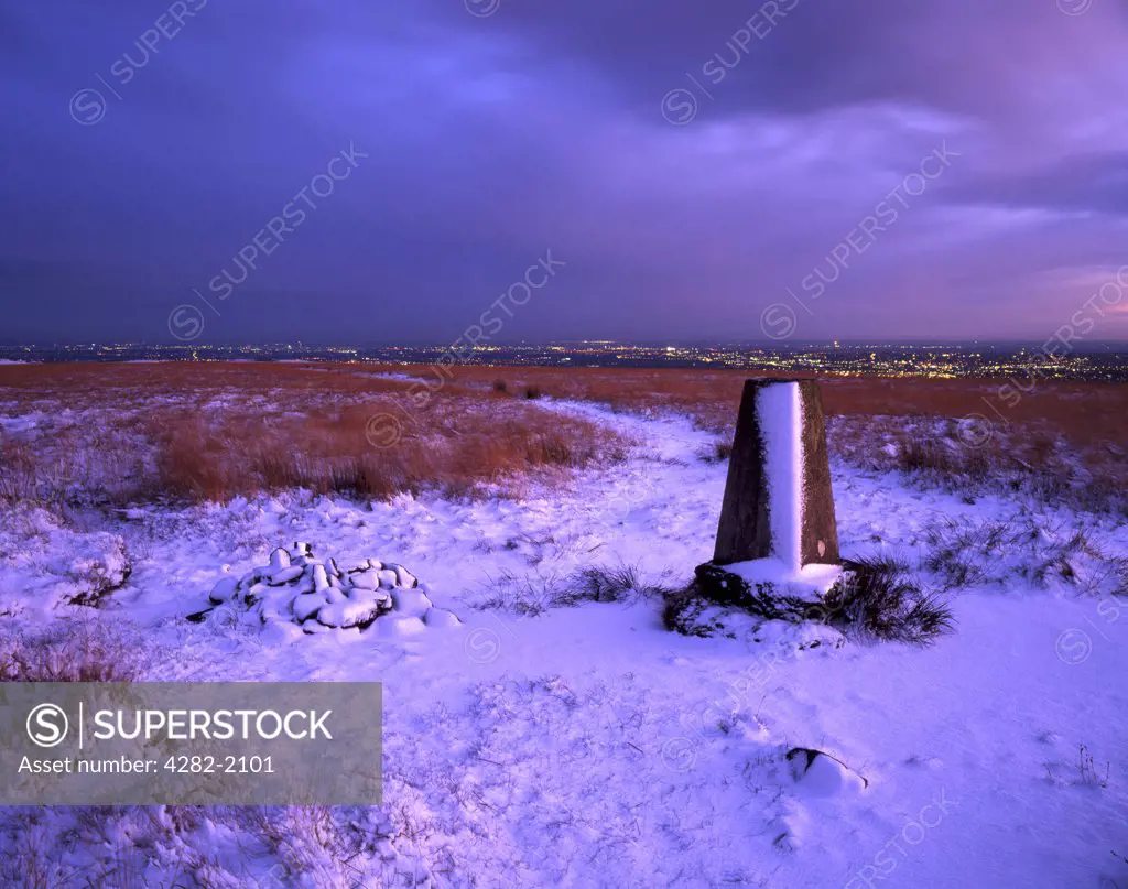 England, Lancashire, Cheetham Close. The trig point on Cheetham Close (329m) offers good views of the lights of Bolton at dusk. A trig point is a fixed station for surveying projects on nearby area.