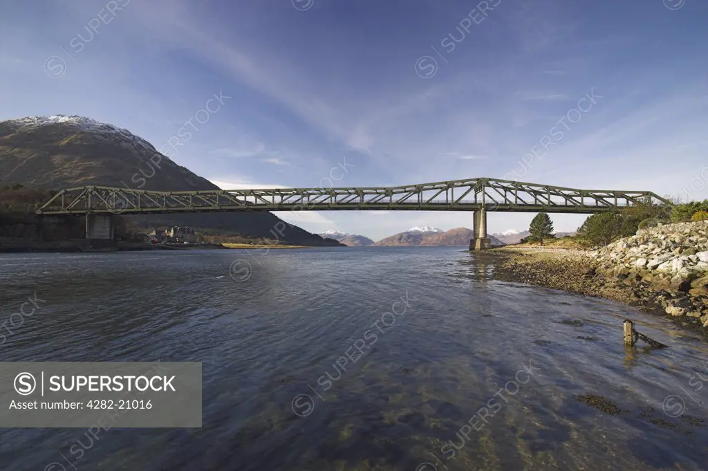 Scotland, Highland, Ballachulish. View of Ballachulish Bridge connecting North and South Ballachulish over Loch Leven with snow covered mountains in the distance.
