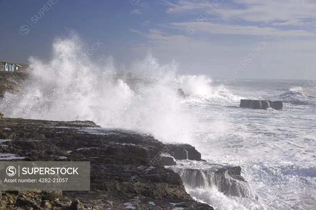 England, Dorset, Portland Bill. Waves from a stormy sea crash against the rocky mainland at Portland Bill.