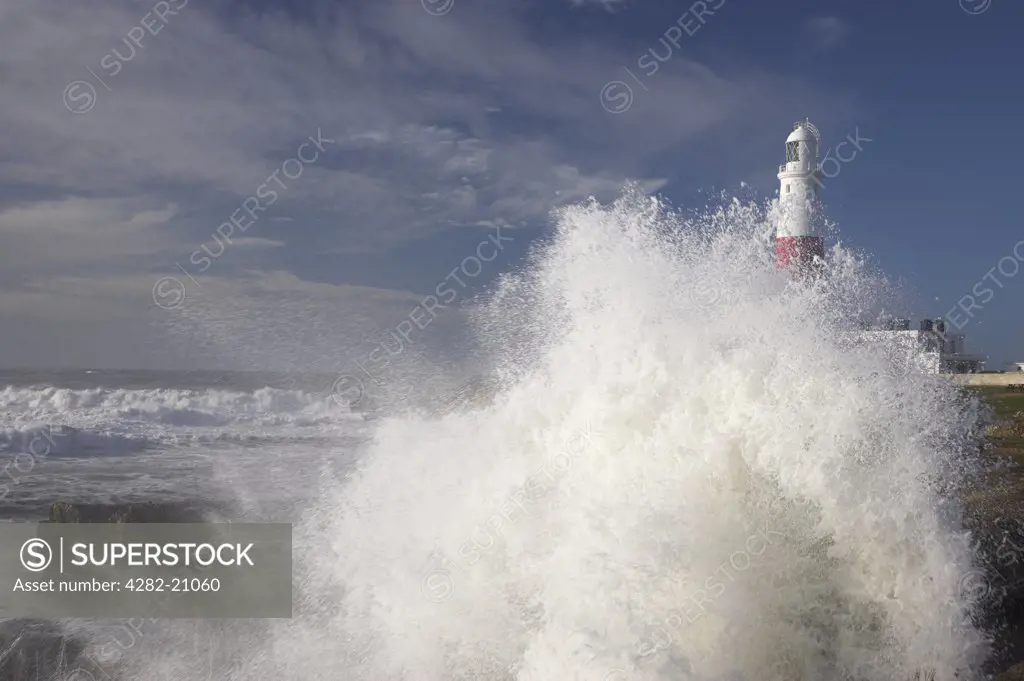 England, Dorset, Portland Bill. Stormy waves crashing onto the rocks by Portland Bill Lighthouse in Dorset.