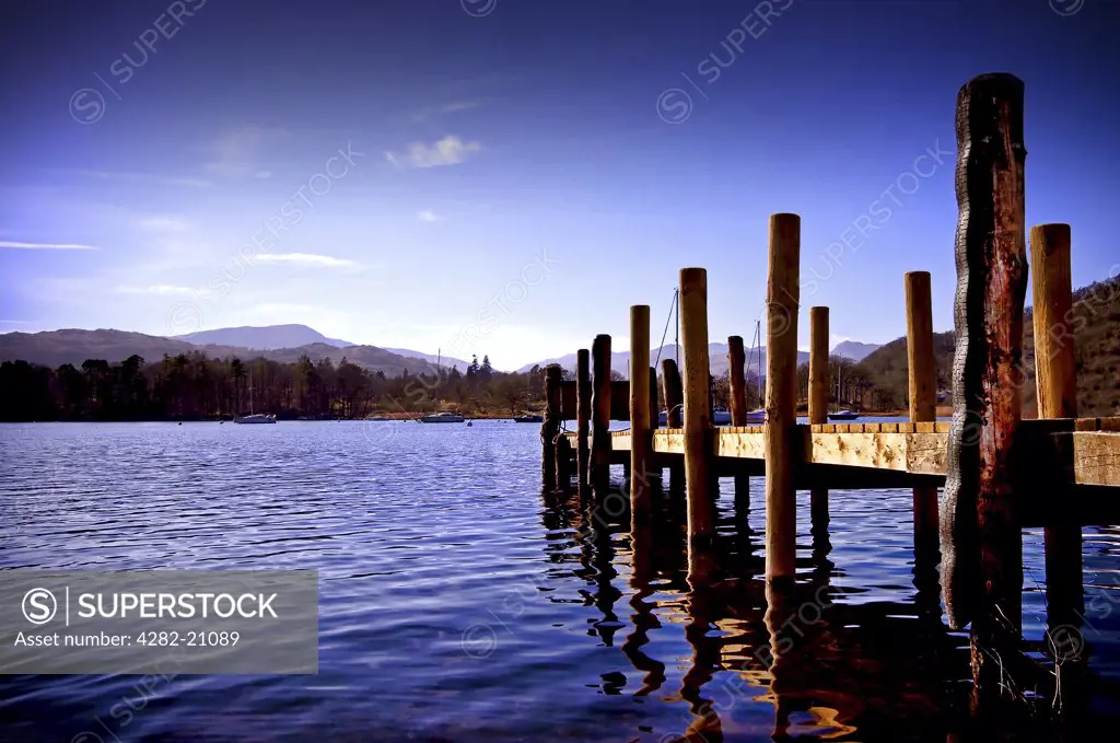 England, Cumbria, Windemere. A view of a wooden jetty at Lake Windemere.