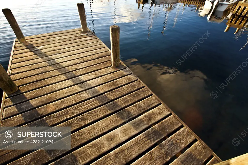 England, Cumbria, Windemere. Looking into the water from a wooden jetty on Lake Windemere.