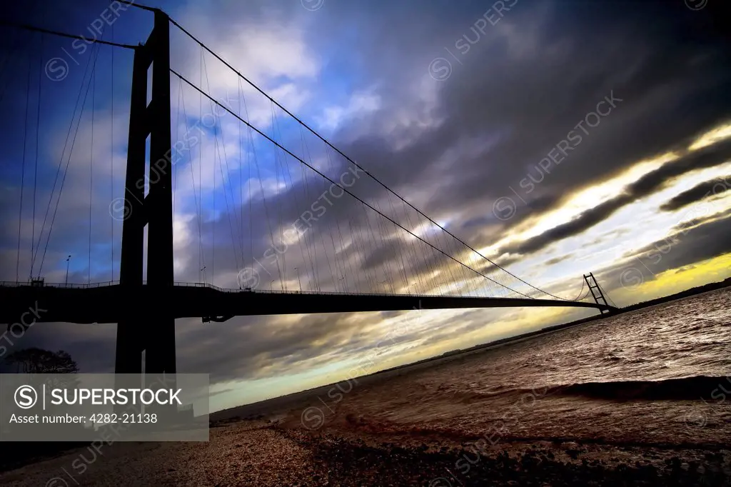 England, East Yorkshire, Humber Bridge. A view from the river bank of the Humber Bridge at sunset.
