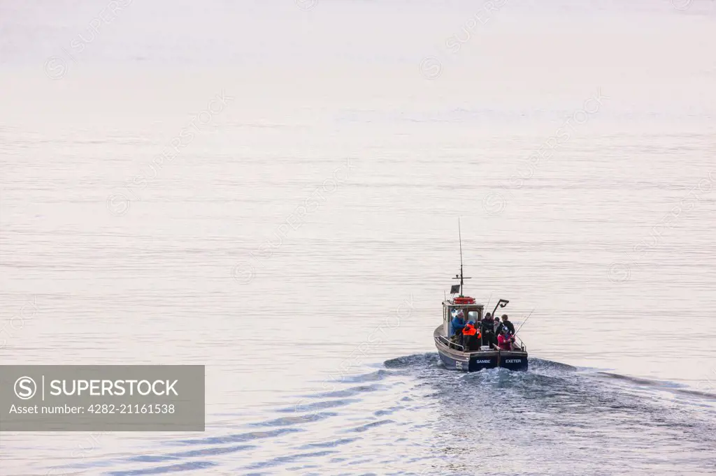 A sea fishing party heads out across calm waters.