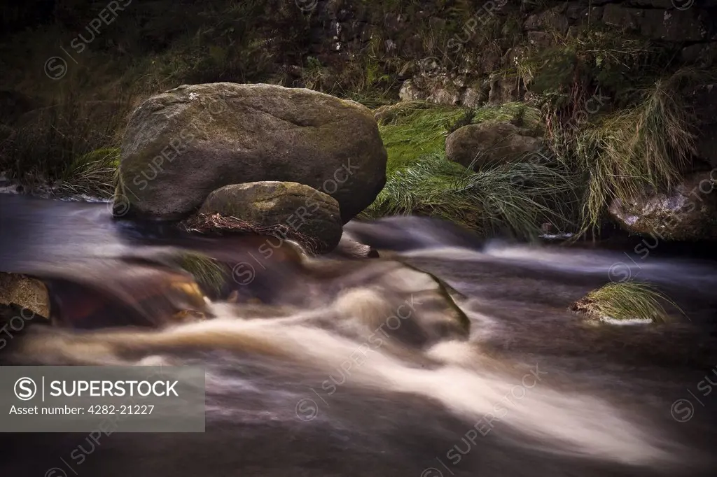 England, Cumbria, Lake District. Fast running water cascading over rocks in a stream in the Lake District.