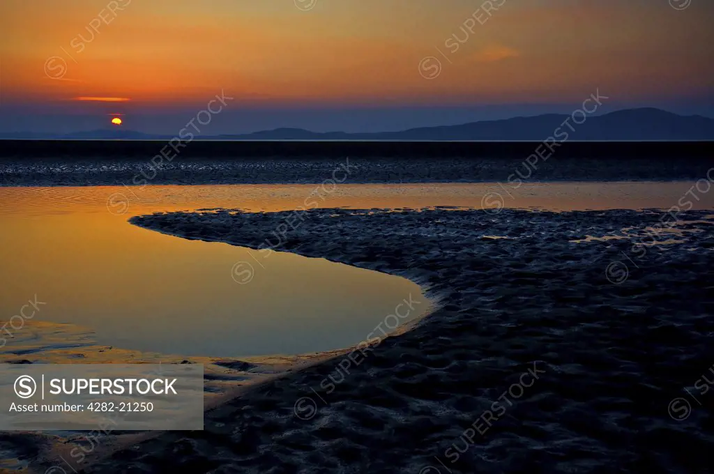 England, Cumbria, Silloth. Sunset over the Bay of Solway with Mount Criffel on the horizon.