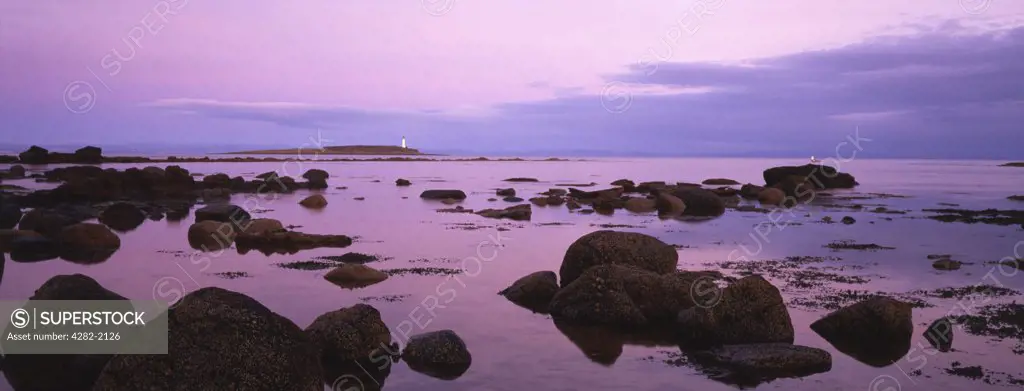 Scotland, North Ayrshire, Isle of Arran. Dusk falls on the lighthouse on Pladda just off the southern shore of Arran. In the 2001 census the Isle of Arran had a resident population of 5,058.