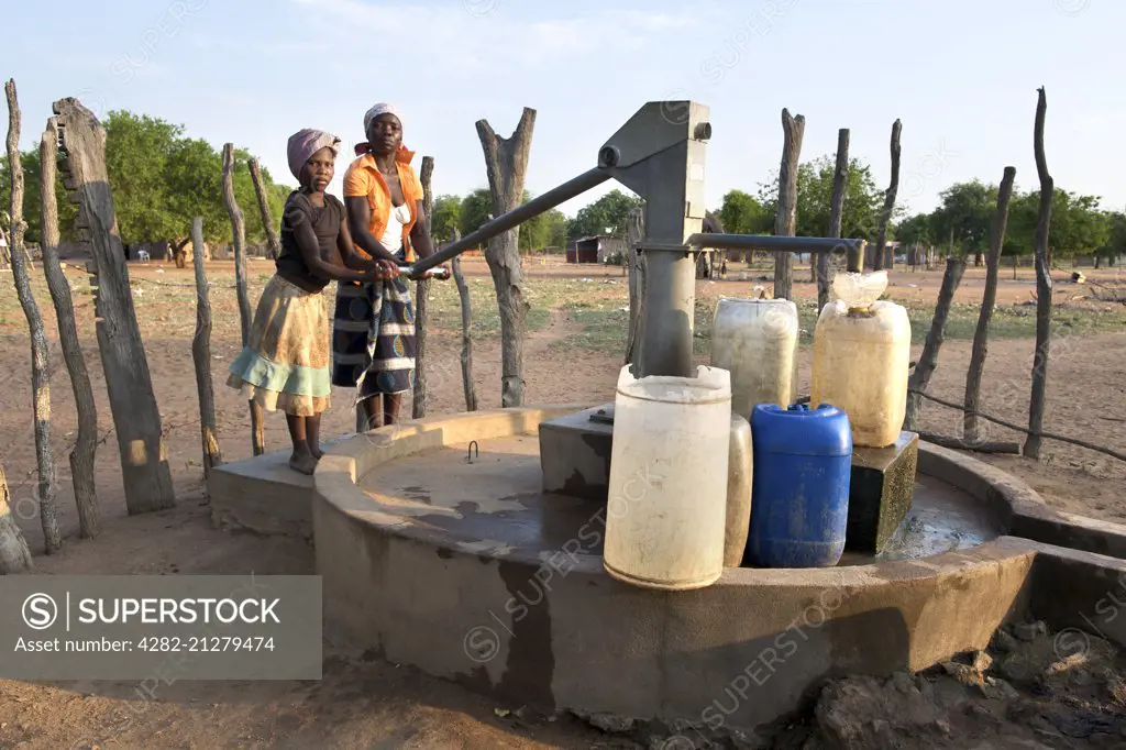 Two African women pumping water in the Mozambican town of Mpelane.