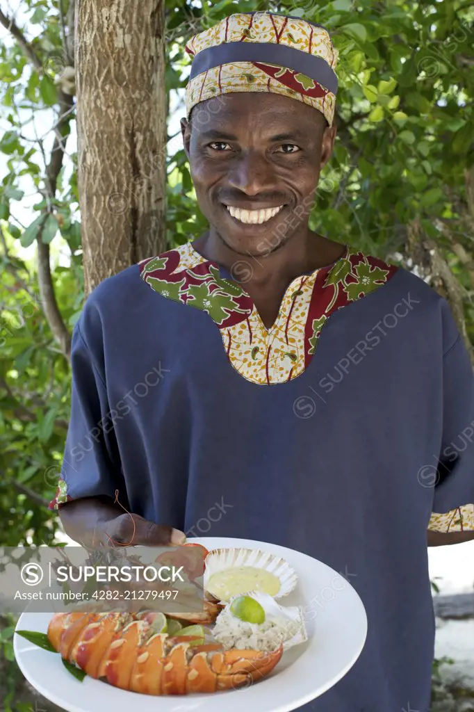 Waiter with lobster lunch dish at Guludo beach lodge in the Quirimbas National Park in northern Mozambique.
