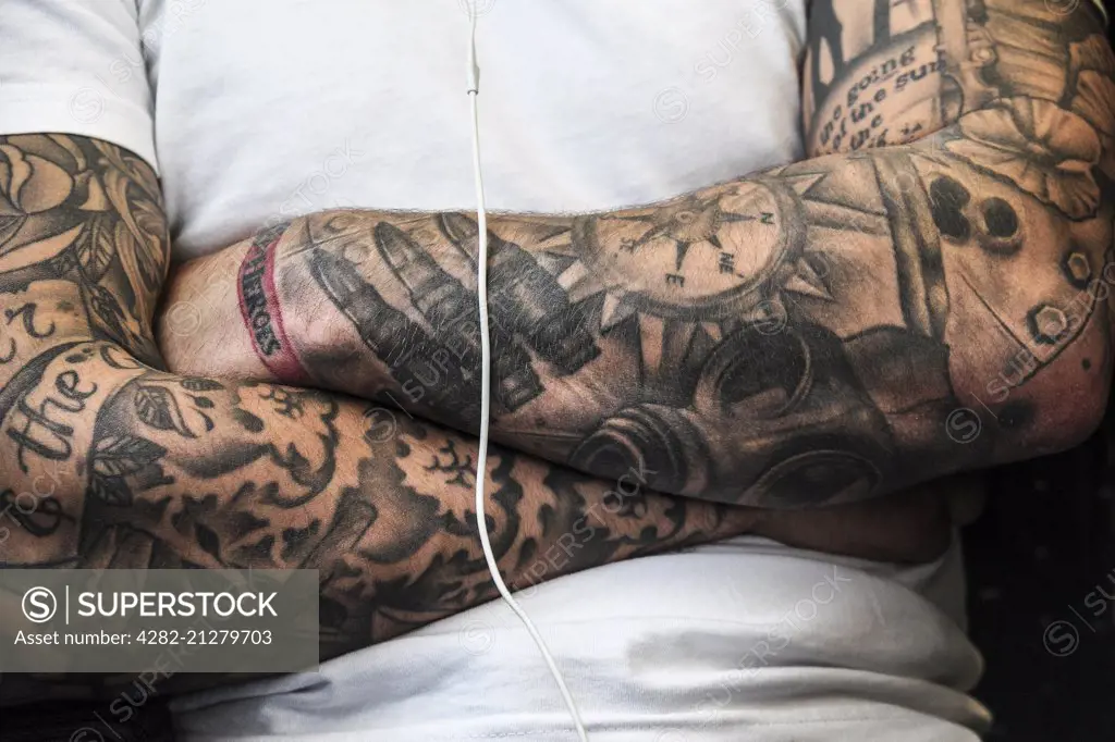 A man with heavily tattooed arms.