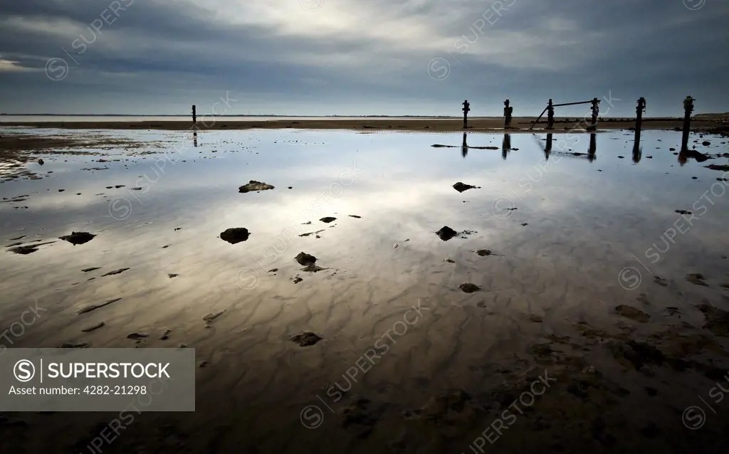 England, East Yorkshire, Spurn Point. View of old water breakers and the sandy beach at Spurn Point.