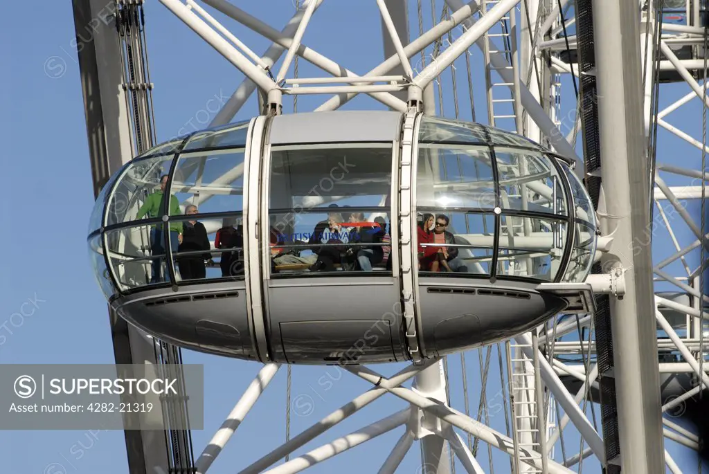 England, London, South Bank. People in a capsule of the London Eye. It is officially the world's most popular tourist attraction, more popular than the Statue of Liberty and the Eiffel Tower.