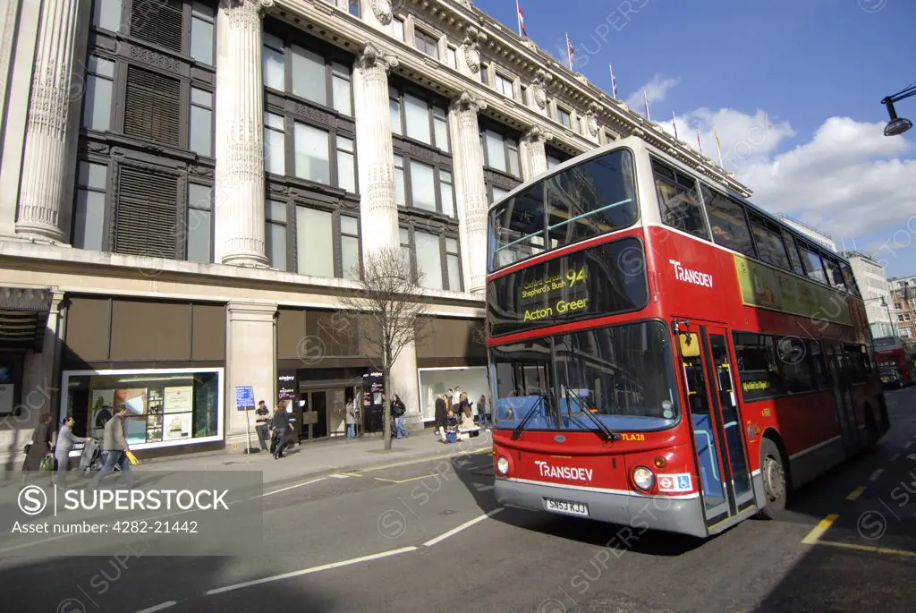 England, London, Oxford Street. A red double decker bus travelling along Oxford Street.