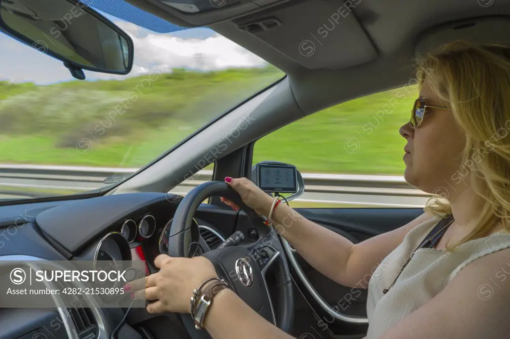 Young woman driving fast along a motorway.