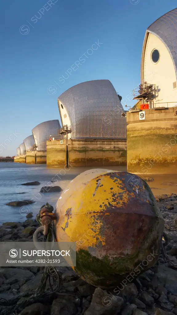 England, London, Woolwich. Thames Barrier at sunset. Built in 1984 as London's flood defence, the 1716 feet width of the river is divided by nine reinforced concrete piers to form six openings for shipping.