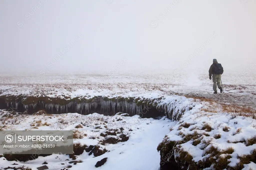 England, North Yorkshire, Whernside. Hill walker on icy fells near the summit of Whernside in the Yorkshire Dales.