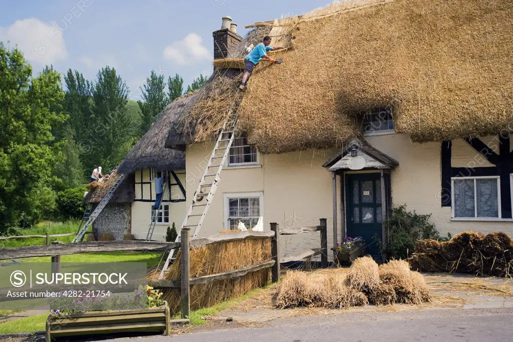 England, West Sussex, Midhurst. Work to replace a traditional thatched roof on a cottage.