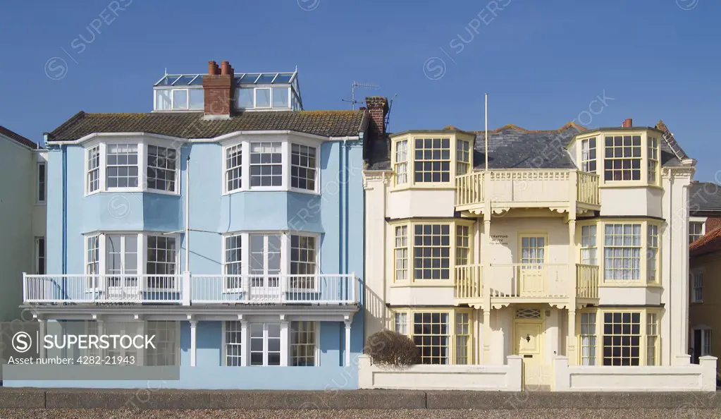 England, Suffolk, Alderburgh. Blue and Yellow houses on the seafront in Alderburgh. Aldeburgh survived principally as a fishing village until the nineteenth century, when it became popular as a seaside resort.