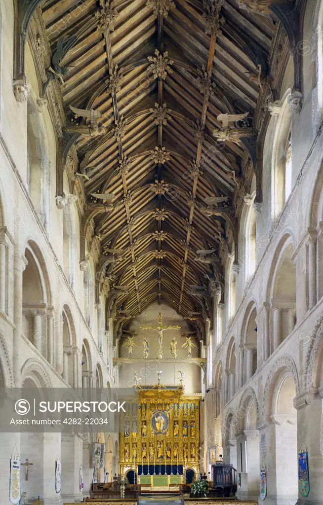 England, Norfolk, Wymondham. Wymondham Abbey showing nave and gilded reredos.