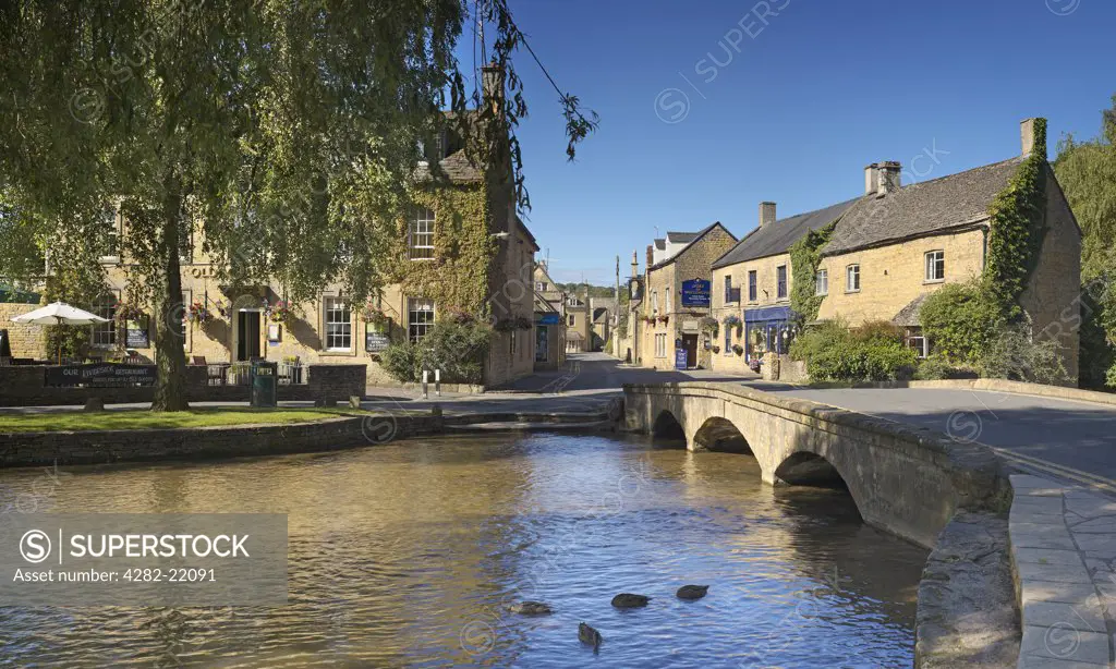 England, Gloucestershire, Bourton-on-the-Water. Looking across the River Windrush to the Old Manse Hotel in Bourton on the Water.