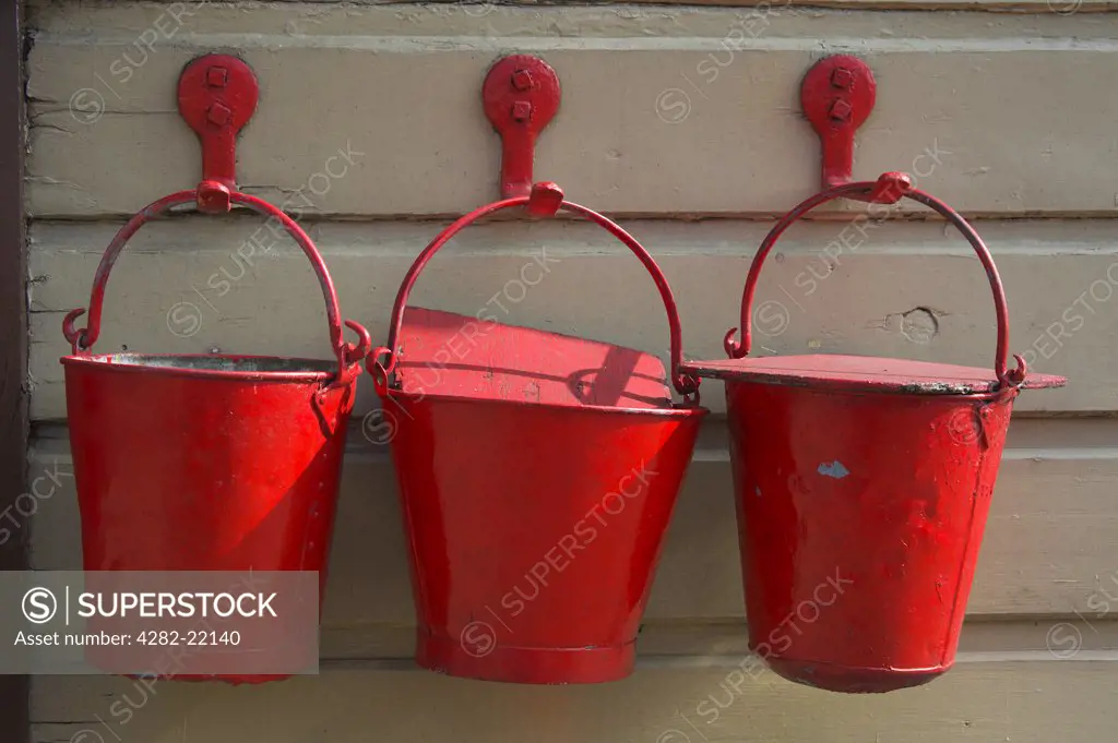 England, Cambridgeshire, Wansford. Three red fire buckets on a platform at Wansford station.