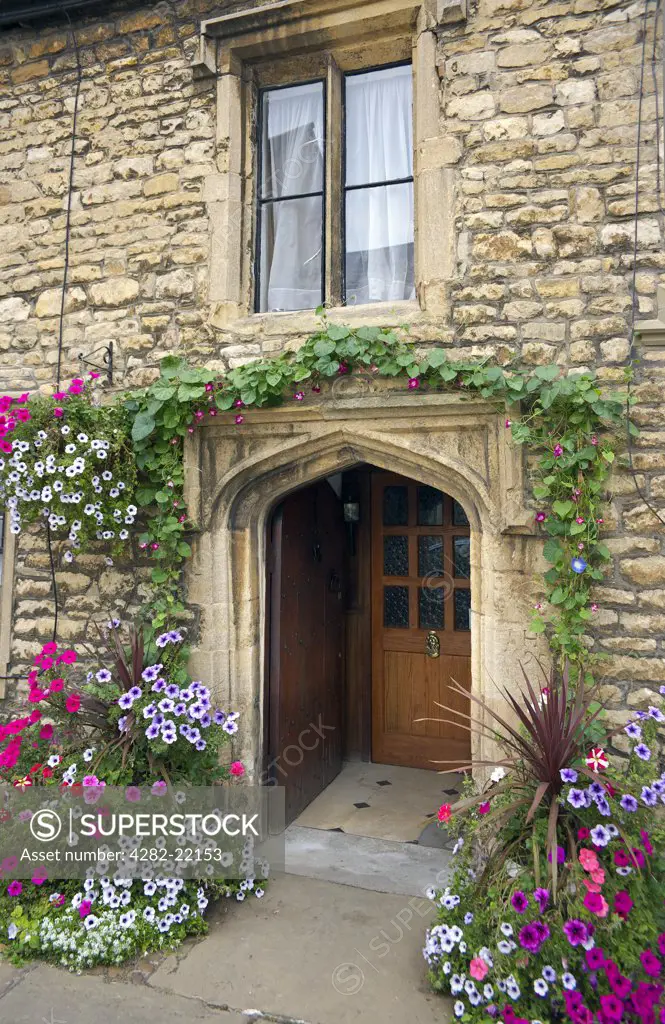 England, Lincolnshire, Stamford. Flowers around the entrance to an old house in Stamford.