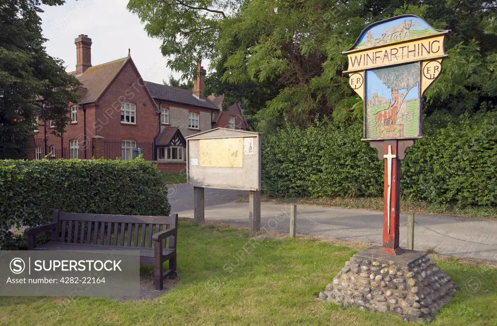 England, Norfolk, Winfarthing. Village sign and park bench in Winfarthing.