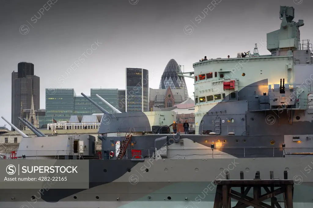 England, London, Tower Bridge. A view of HMS Belfast with the City of London skyline behind.