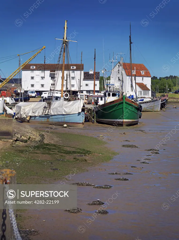England, Suffolk, Woodbridge. Old boats moored by the Tide Mill on the River Deben.