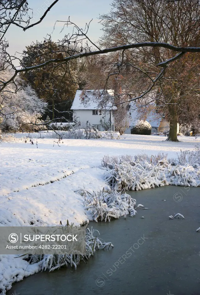 England, Essex, Near Saffron Walden. Snow covering the ground around a farmhouse in East Anglia.