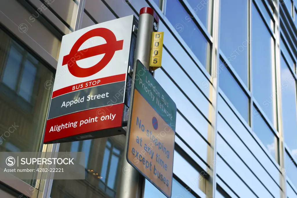 England, London, City of London. A bus stop sign outside modern office buildings on Appold Street.
