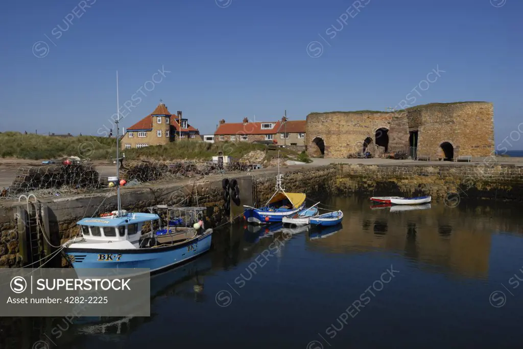 England, Northumberland, Beadnell. Small boats in Beadnell Harbour and the remains of the lime kilns, the earliest of which dates back to 1789.