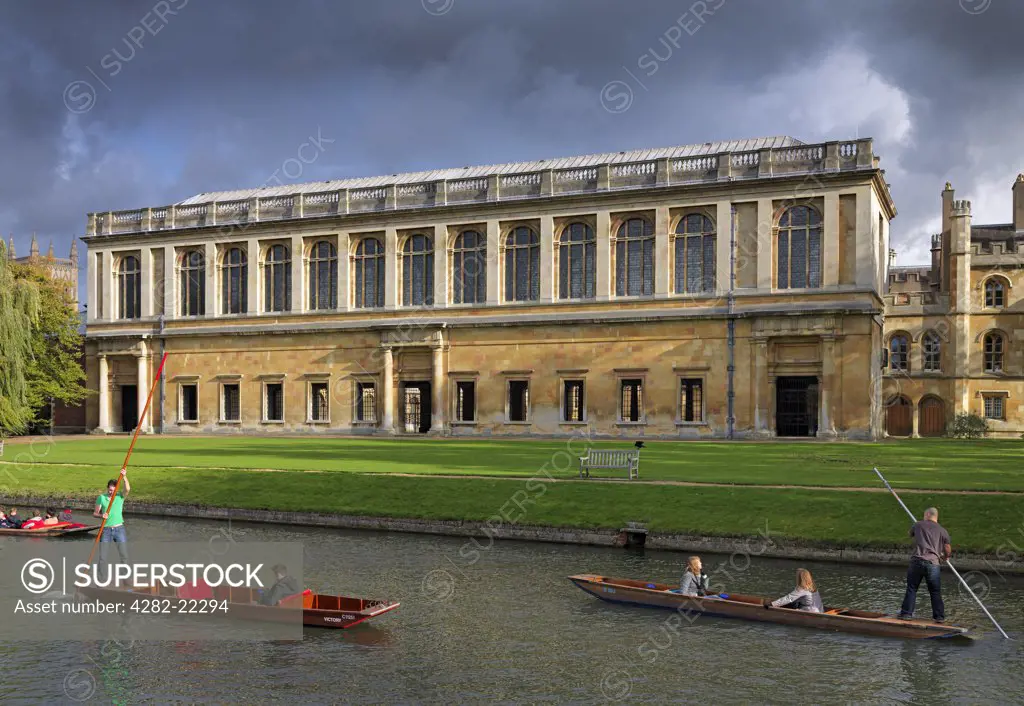 England, Cambridgeshire, Cambridge. Punting on the River Cam in front of The Wren Library, part of Trinity College Cambridge.