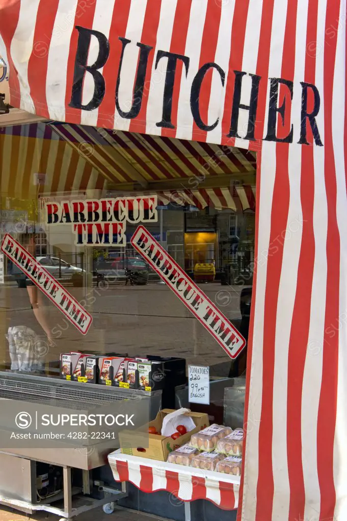 England, Cambridgeshire, Ely. A stripy awning over the shop front of an English Butcher shop.
