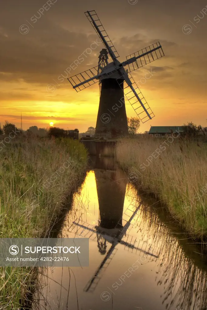 England, Norfolk, Thurne. St Benets Wind Pump at sunrise on a spring morning.