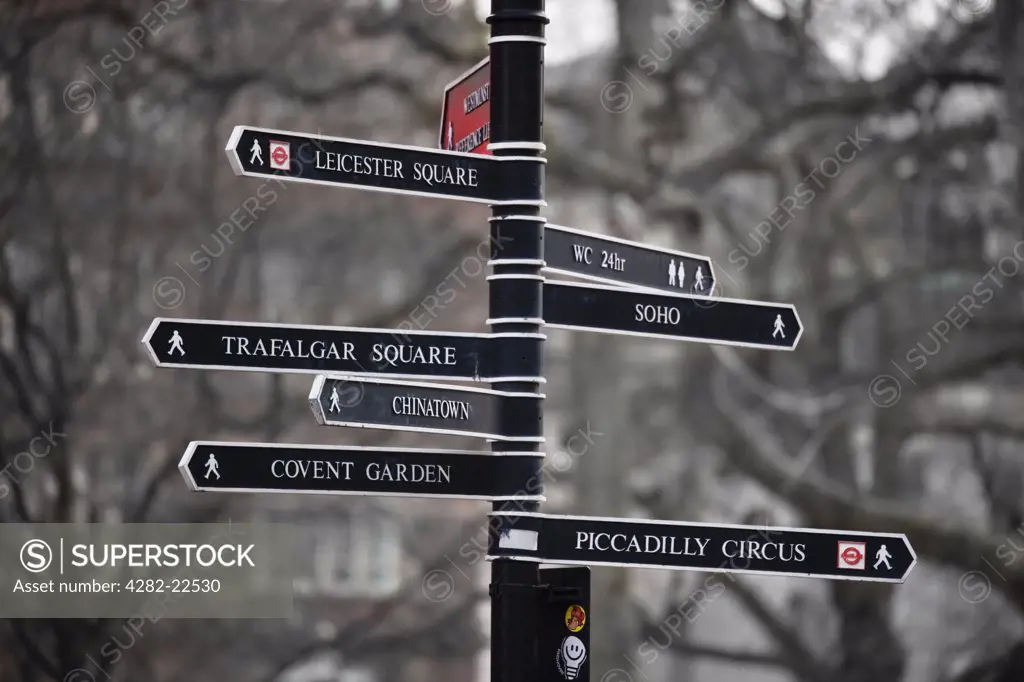 England, London, Piccadilly. A black and white metal sign post pointing to many famous places in London.