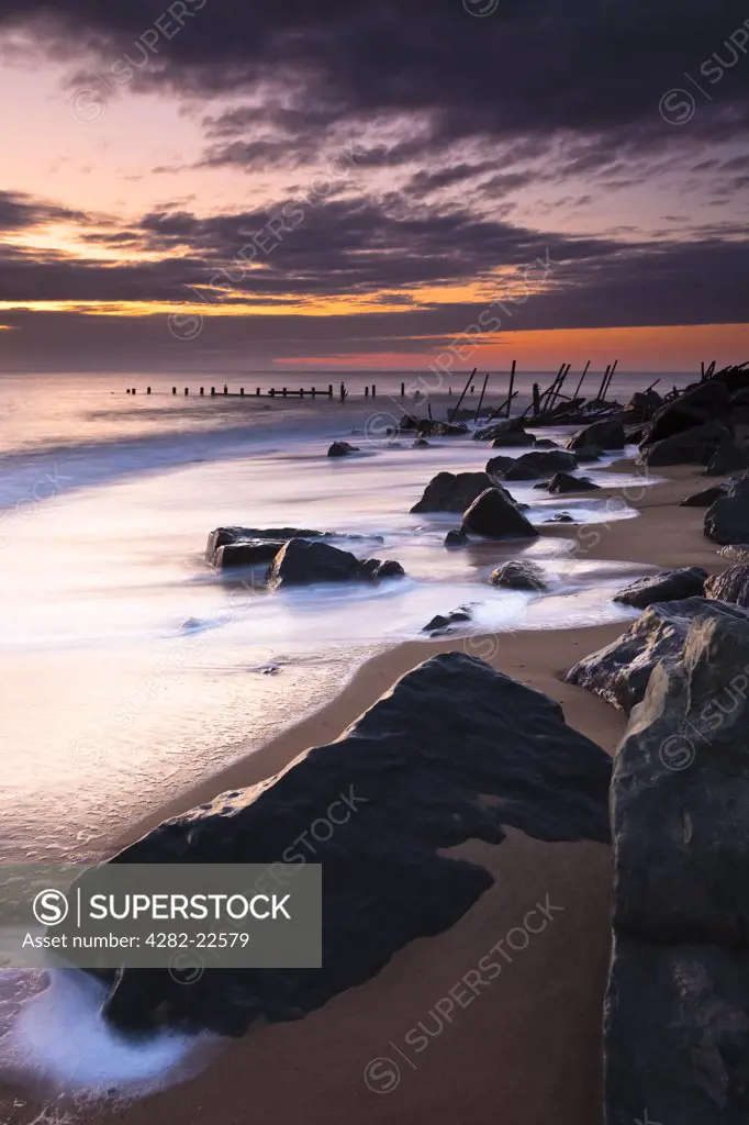 England, Norfolk, Happisburgh. Dawn light over the remains of Happisburghs' sea defences.