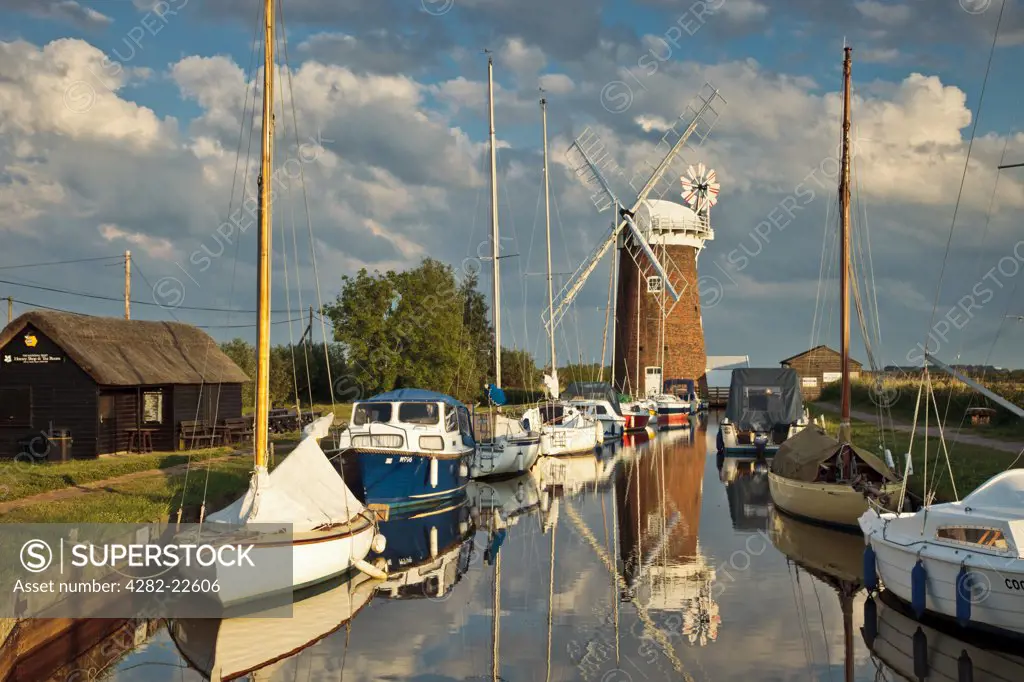 England, Norfolk, Horsey. Relections of Horsey Windpump and boats in Horsey Mere on the Norfolk Broads.