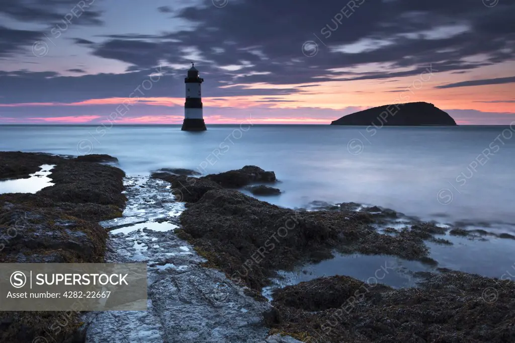 Wales, Anglesey, Penmon. Penmon lighthouse and Puffin Island at Penmon Point on the Isle of Anglesey at dawn.